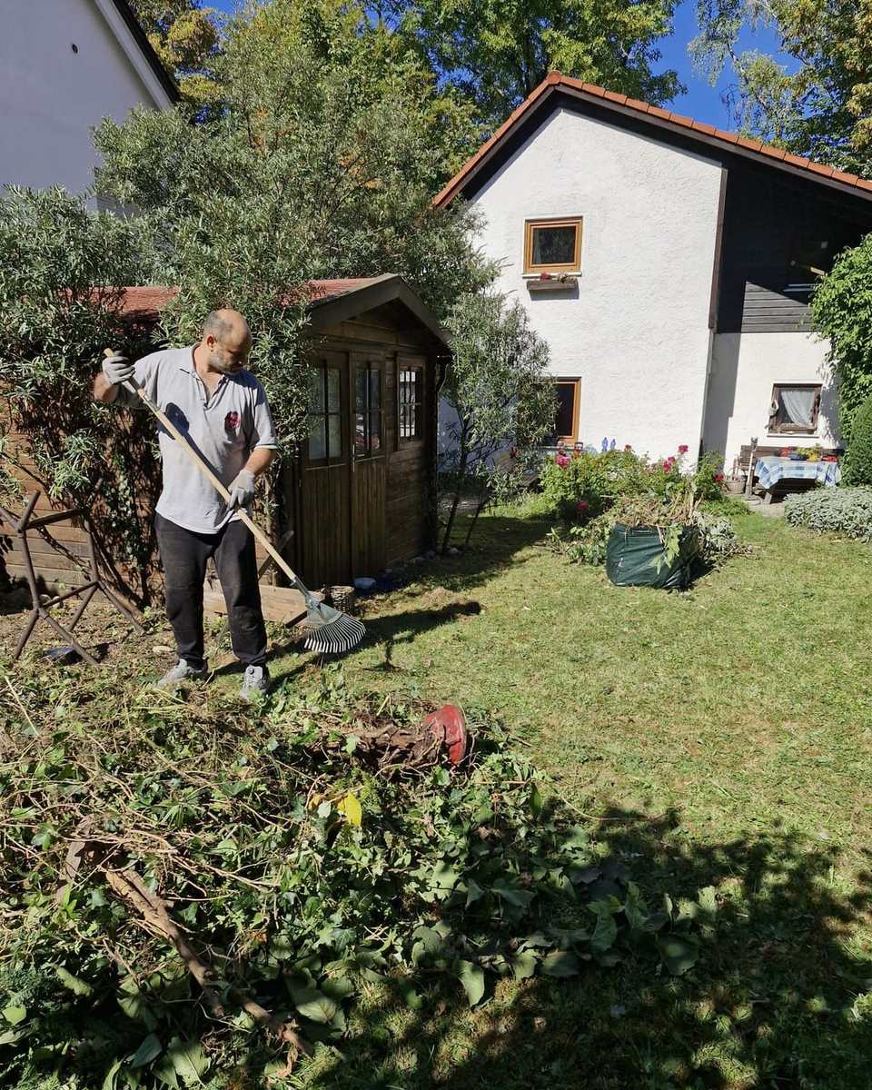 Gartenarbeit an einem sonnigen Tag mit Grünschnitt im Vordergrund