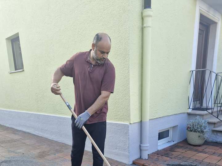 Kehren einer Pflasterfläche vor dem Haus