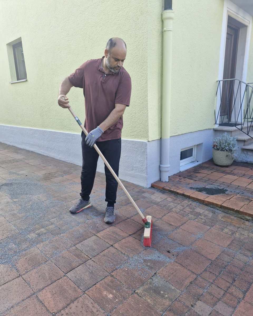 Kehren einer Pflasterfläche vor dem Haus